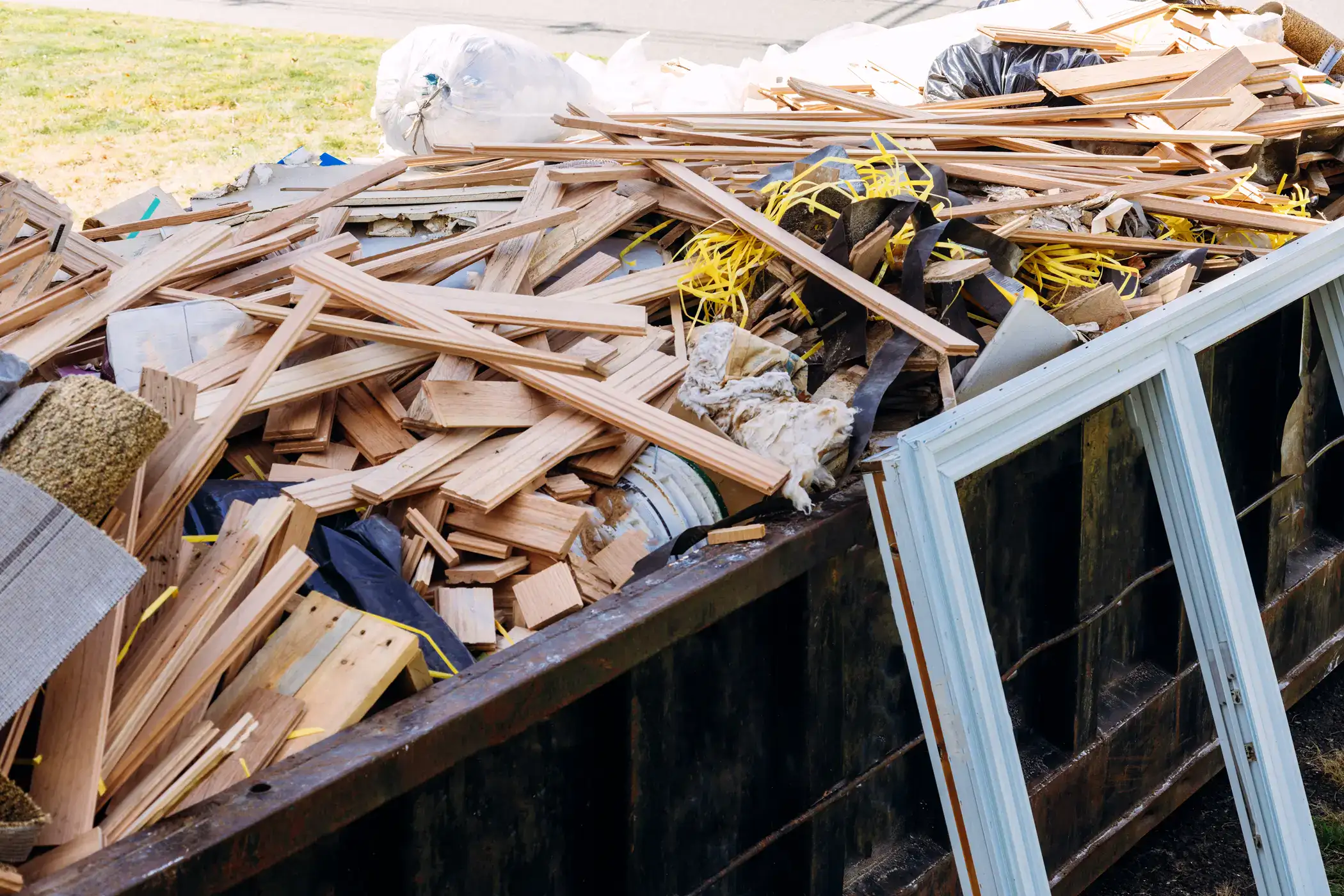 Altmaterialien und Holzreste in Containern.